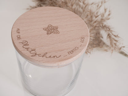 Glas mit Holzdeckel und Gravur „Auf die Plätzchen … fertig … los“ gefüllt mit Weihnachtsplätzchen. Daneben liegen Zimtsterne und Vanillekipferl auf hellem Hintergrund – stimmungsvolles, nordisch-cleanes Weihnachtsmotiv.