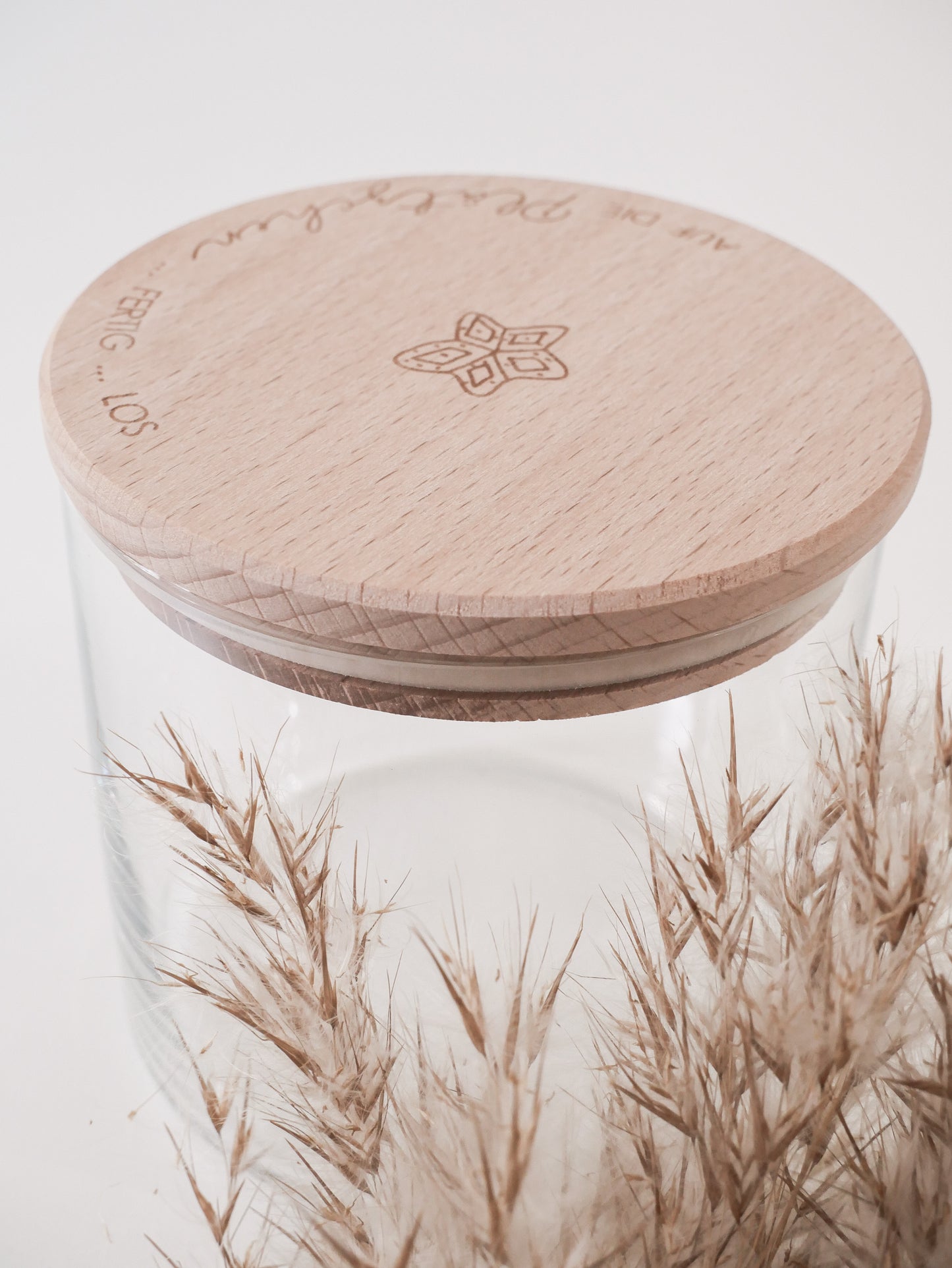 Glas mit Holzdeckel und Gravur „Auf die Plätzchen … fertig … los“ gefüllt mit Weihnachtsplätzchen. Daneben liegen Zimtsterne und Vanillekipferl auf hellem Hintergrund – stimmungsvolles, nordisch-cleanes Weihnachtsmotiv.