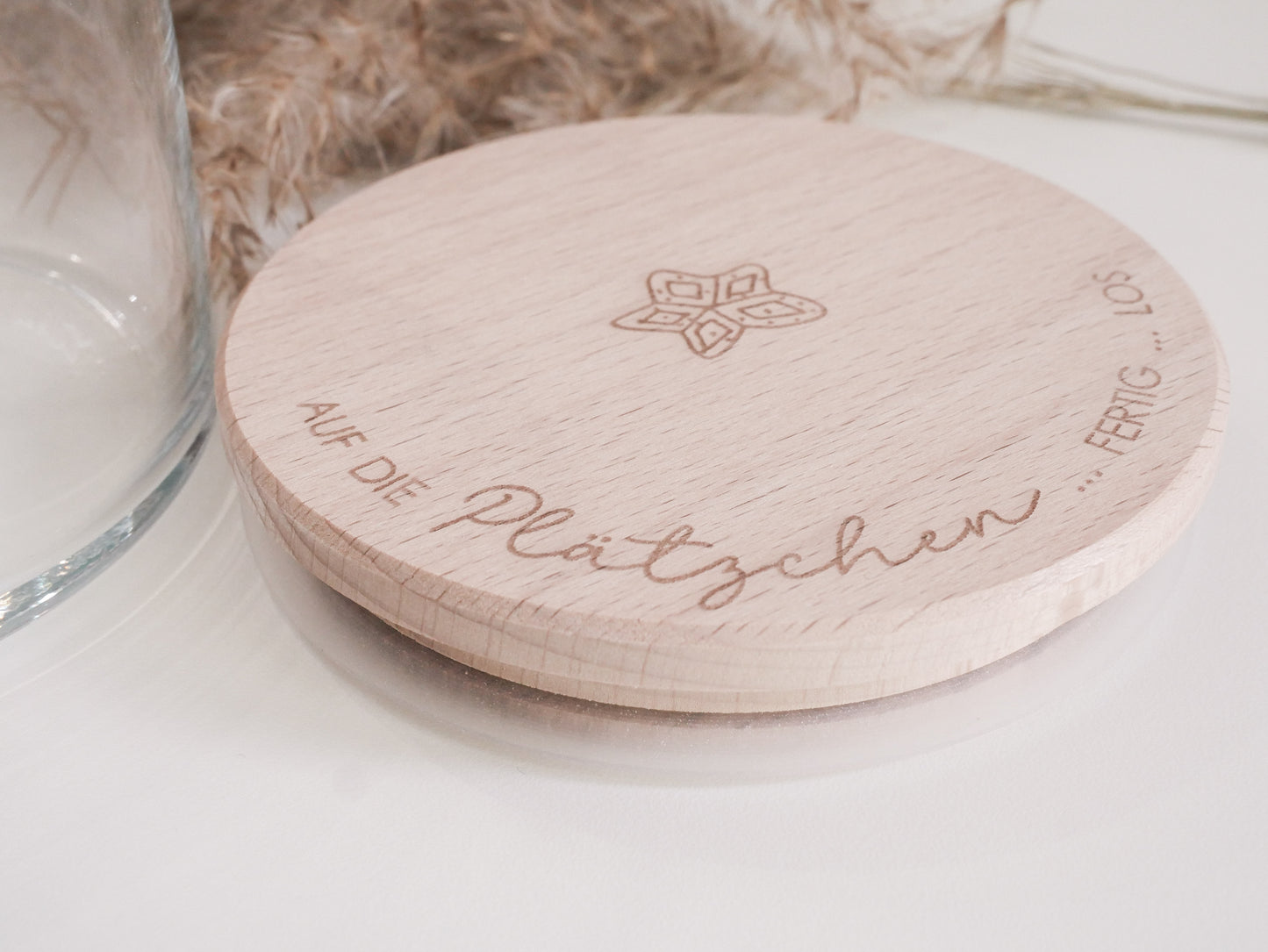 Glas mit Holzdeckel und Gravur „Auf die Plätzchen … fertig … los“ gefüllt mit Weihnachtsplätzchen. Daneben liegen Zimtsterne und Vanillekipferl auf hellem Hintergrund – stimmungsvolles, nordisch-cleanes Weihnachtsmotiv.