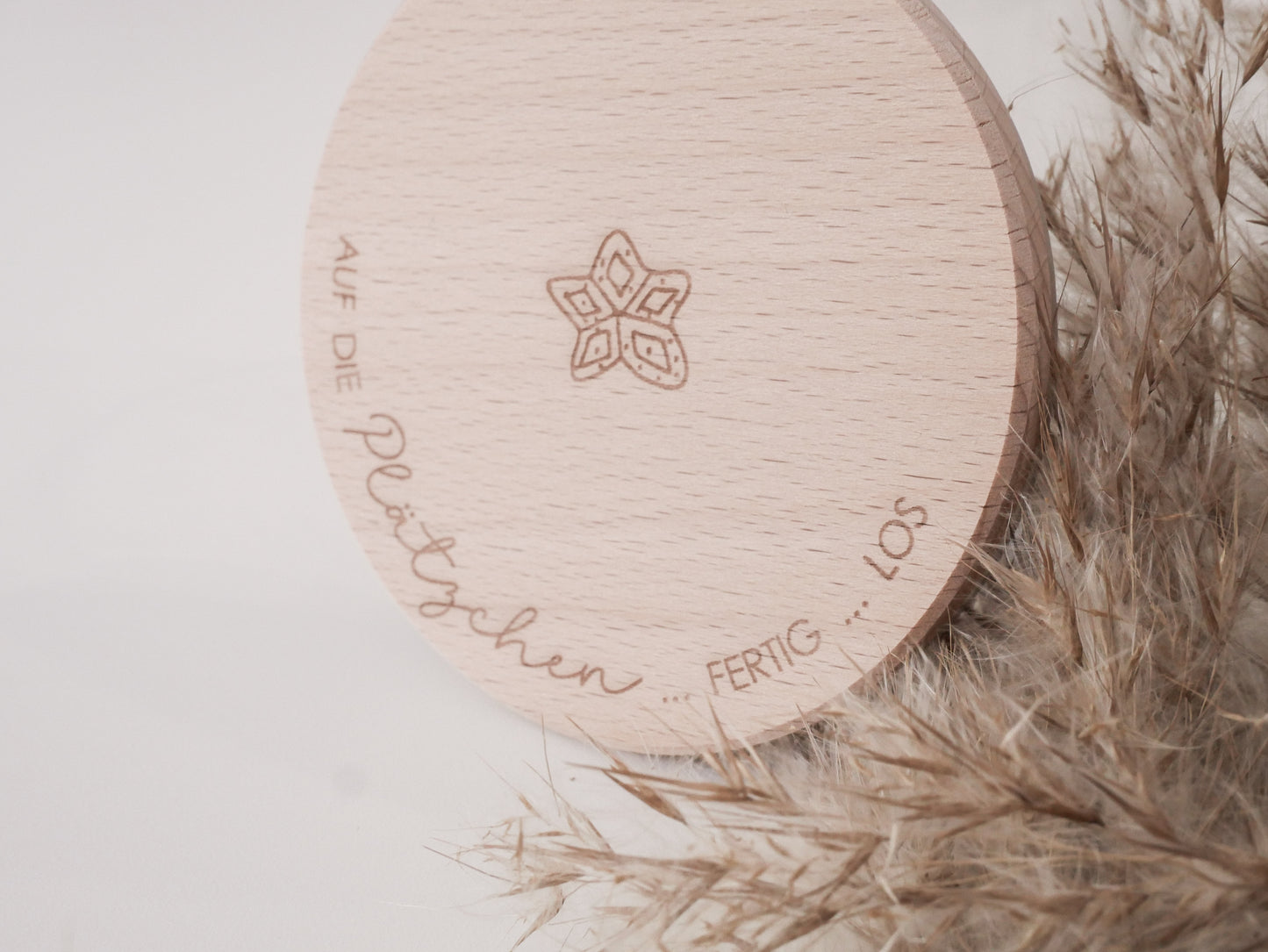 Glas mit Holzdeckel und Gravur „Auf die Plätzchen … fertig … los“ gefüllt mit Weihnachtsplätzchen. Daneben liegen Zimtsterne und Vanillekipferl auf hellem Hintergrund – stimmungsvolles, nordisch-cleanes Weihnachtsmotiv.