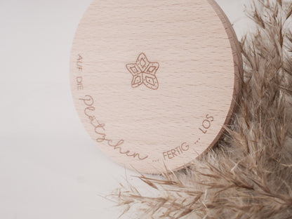 Glas mit Holzdeckel und Gravur „Auf die Plätzchen … fertig … los“ gefüllt mit Weihnachtsplätzchen. Daneben liegen Zimtsterne und Vanillekipferl auf hellem Hintergrund – stimmungsvolles, nordisch-cleanes Weihnachtsmotiv.