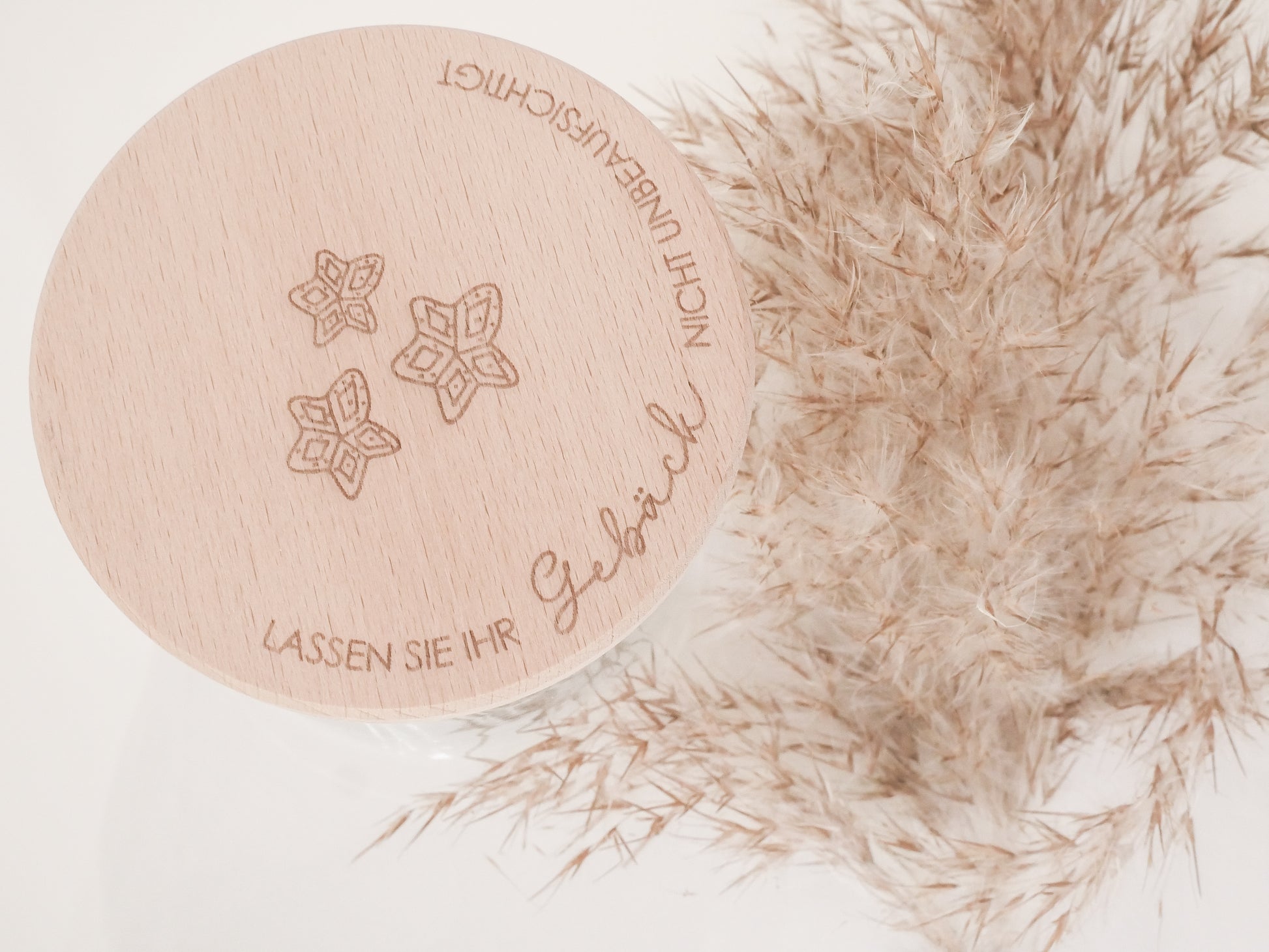 Handgefertigtes Vorratsglas mit graviertem Holzdeckel und Aufschrift „Lassen Sie Ihr Gebäck nicht unbeaufsichtigt“, dekoriert mit feinen Schneeflocken. Ein liebevolles Detail für jede Küche – natürlich, stilvoll und von Leo & Lu.