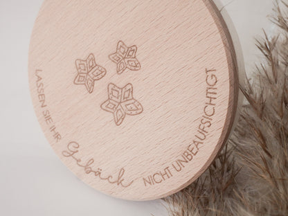 Handgefertigtes Vorratsglas mit graviertem Holzdeckel und Aufschrift „Lassen Sie Ihr Gebäck nicht unbeaufsichtigt“, dekoriert mit feinen Schneeflocken. Ein liebevolles Detail für jede Küche – natürlich, stilvoll und von Leo & Lu.