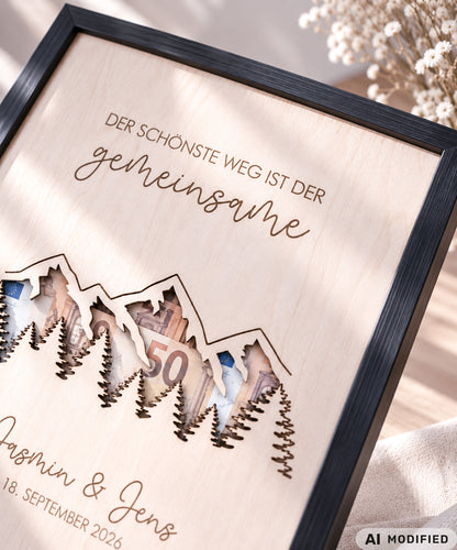 Personalisiertes Geldgeschenk zur Hochzeit aus Holz mit filigran ausgeschnittener Berg- und Waldlandschaft. Hinter den Bergen lassen sich Geldscheine dekorativ platzieren. Mit Gravur „Der schönste Weg ist der gemeinsame“, Namen des Brautpaares und Hochzeitsdatum. Originelles Hochzeitsgeschenk für Braut und Bräutigam, ideal als Geldgeschenk zur Hochzeit, personalisierte Hochzeitsdeko und besondere Geschenkidee für Paare, Bergliebhaber, Wanderfreunde und Naturliebhaber.