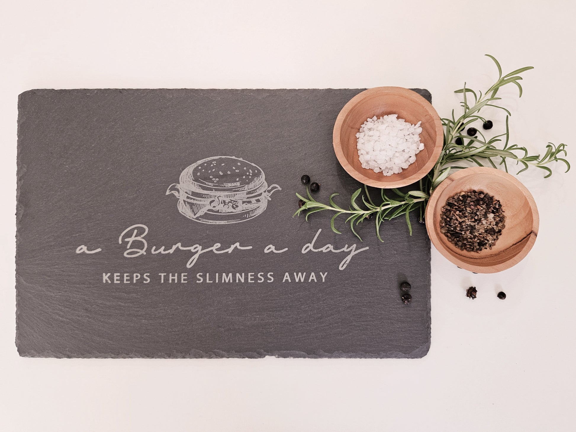 Schieferplatte mit Abbildung eines Burgers und dem Text: a Burger a day keeps the slimmness away