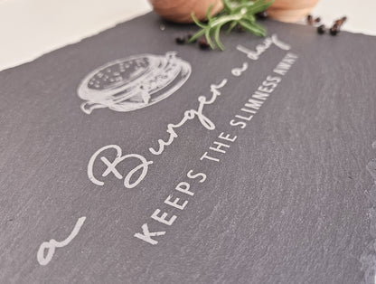 Schieferplatte mit Abbildung eines Burgers und dem Text: a Burger a day keeps the slimmness away