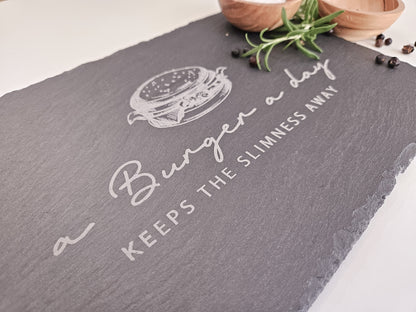 Schieferplatte mit Abbildung eines Burgers und dem Text: a Burger a day keeps the slimmness away