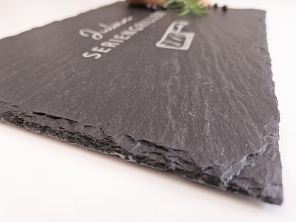 Schieferplatte mit personalisiertem Namen hier in dem Beispiel Julian und darunter die Bezeichnung Seriengriller und ein Messer