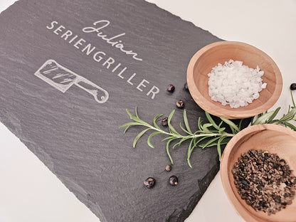 Schieferplatte mit personalisiertem Namen hier in dem Beispiel Julian und darunter die Bezeichnung Seriengriller und ein Messer