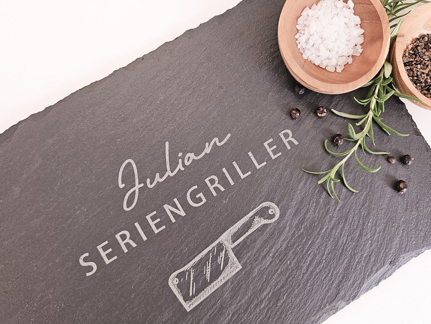 Schieferplatte mit personalisiertem Namen hier in dem Beispiel Julian und darunter die Bezeichnung Seriengriller und ein Messer