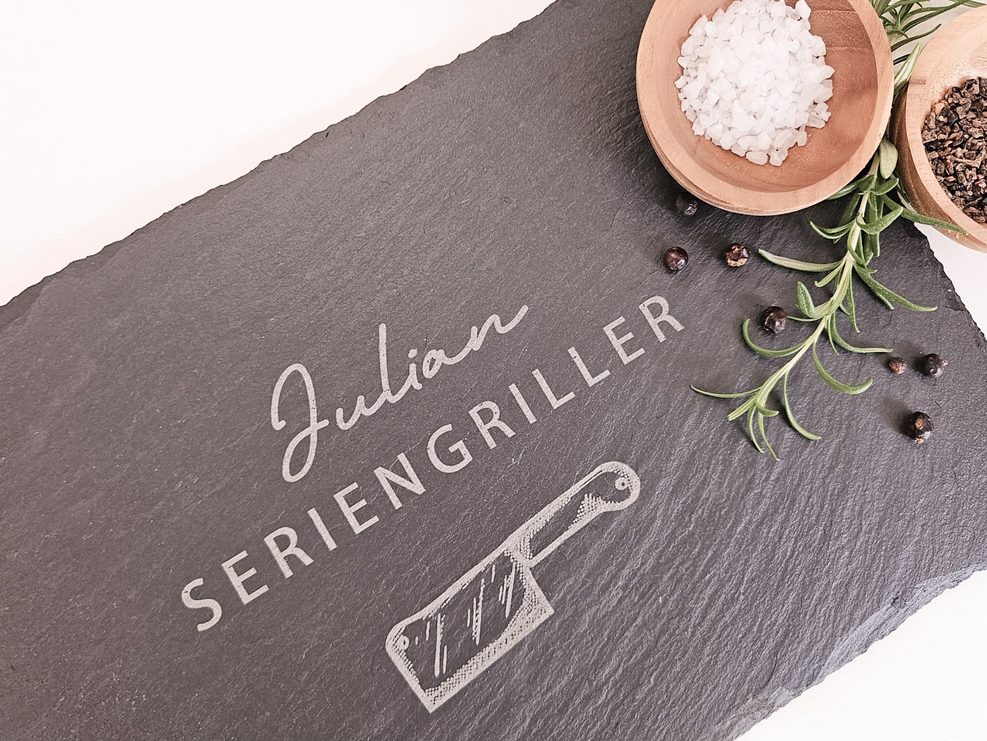 Schieferplatte mit personalisiertem Namen hier in dem Beispiel Julian und darunter die Bezeichnung Seriengriller und ein Messer
