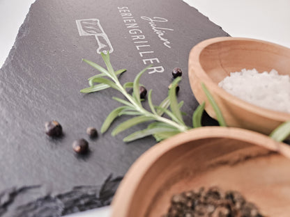 Schieferplatte mit personalisiertem Namen hier in dem Beispiel Julian und darunter die Bezeichnung Seriengriller und ein Messer