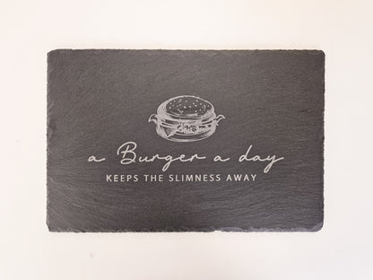Schieferplatte mit Abbildung eines Burgers und dem Text: a Burger a day keeps the slimmness away