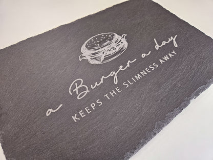 Schieferplatte mit Abbildung eines Burgers und dem Text: a Burger a day keeps the slimmness away