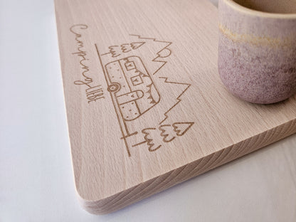 Brottzeitbrett mit Gravur Wohnwagen, Berge und Tannenbäumen inklusive Namen links oben.