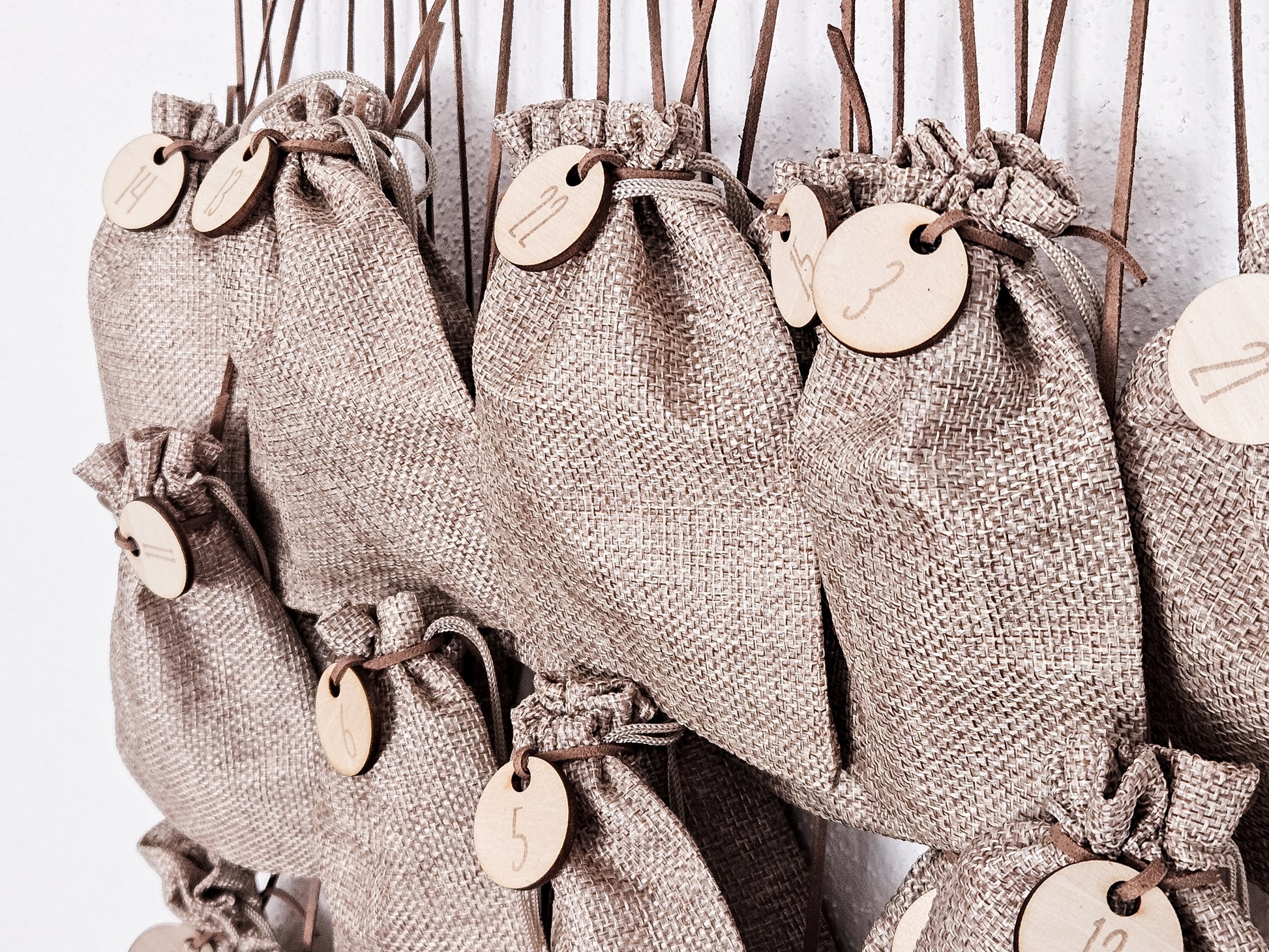 Personalisierter Holz-Adventskalender mit Rentier und Tannenbäumen, Gravur „Adventskalender von Lukas“. Mit 24 nummerierten Holzanhängern zum Aufhängen kleiner Geschenke. Nachhaltige Weihnachtsdekoration für Kinder und Familien.