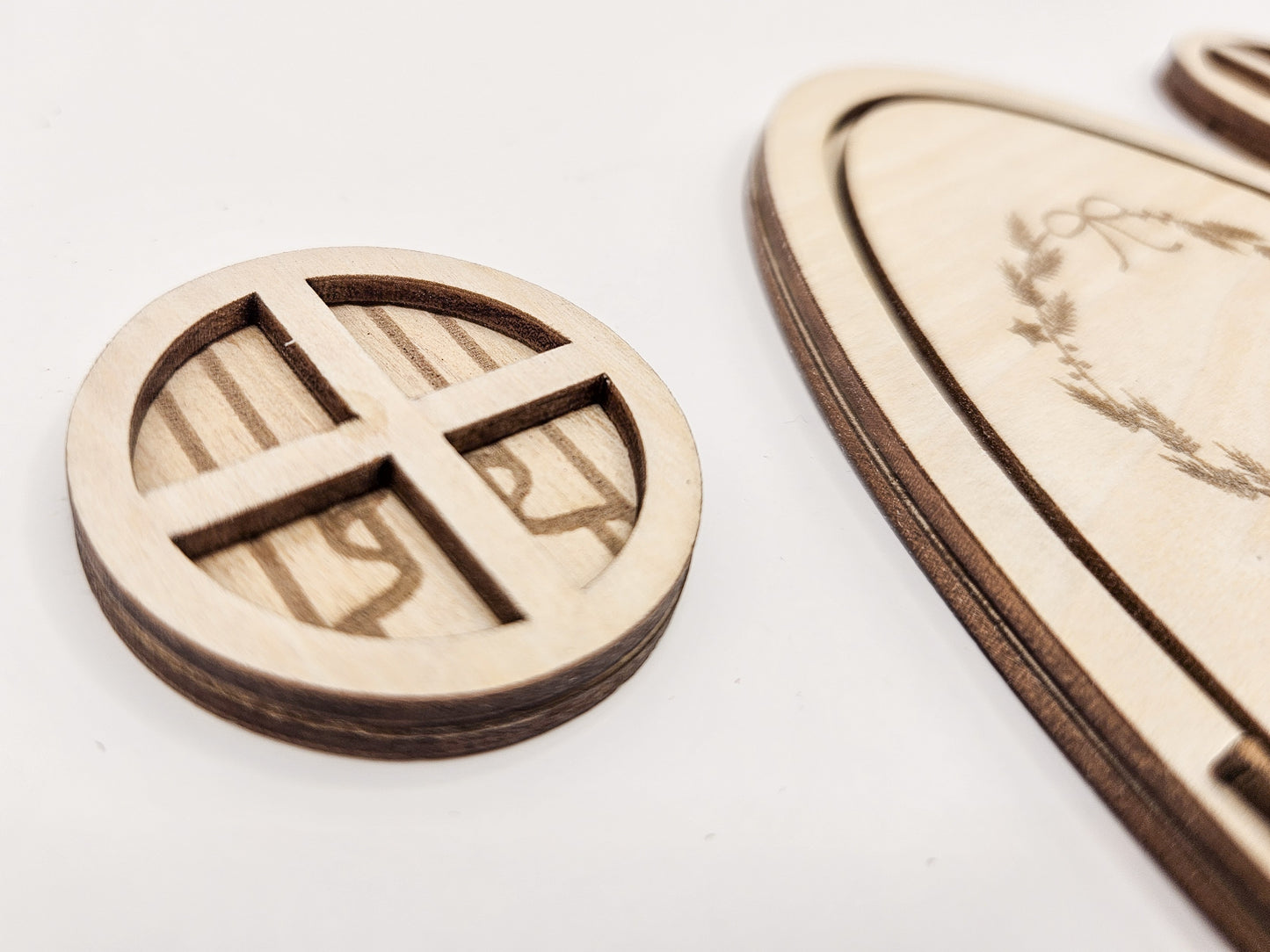 Personalisierbare Holz-Wichteltür mit Leiter, Briefkasten, Pilz und zwei Tannenbäumen an einer weißen Sockelleiste im Kinderzimmer, auf hellblauer Wand mit weißen Punkten montiert.