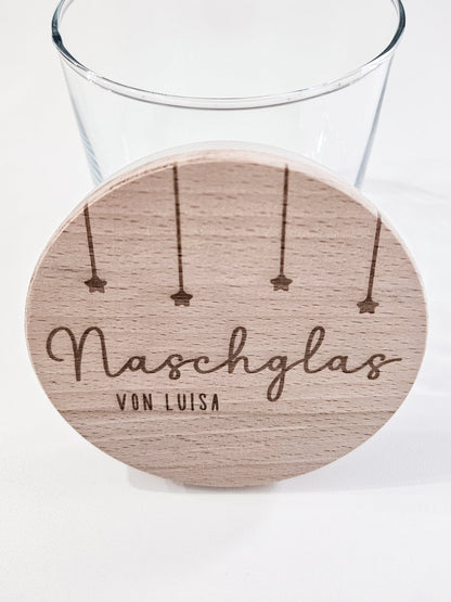 Runder Holzdeckel mit graviertem Schriftzug „Naschglas von Luisa“ und Sternanhängern, auf Glas liegend – personalisierte Geschenkidee.