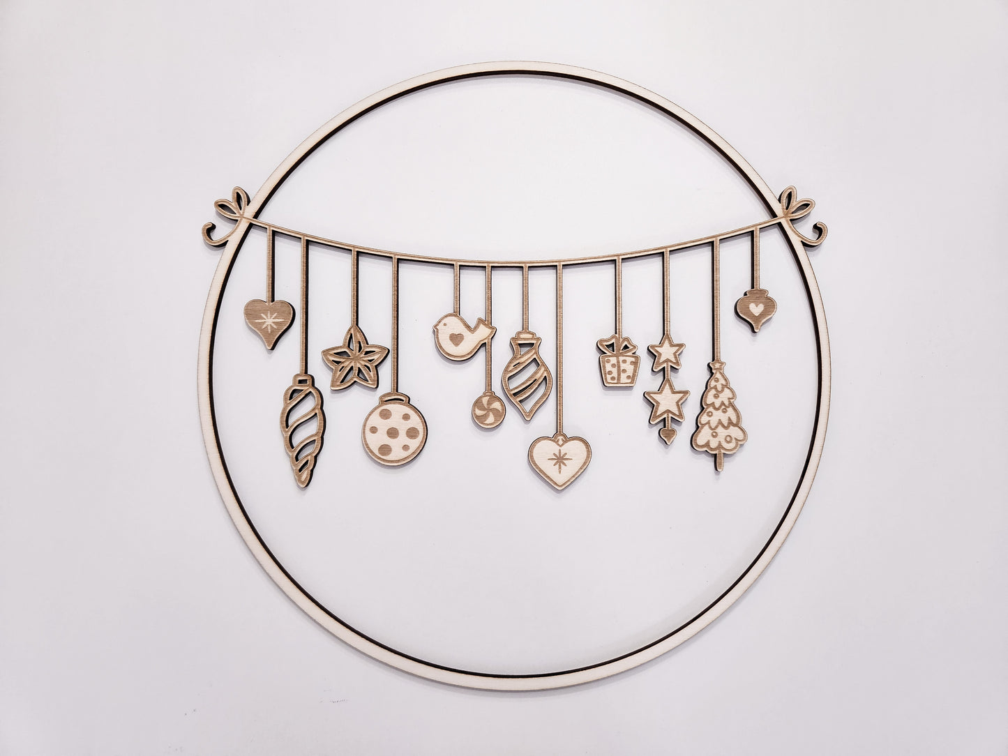 Weihnachtskranz aus Holz mit filigranen Anhängern im skandinavischen Stil als Wand- und Türdeko.