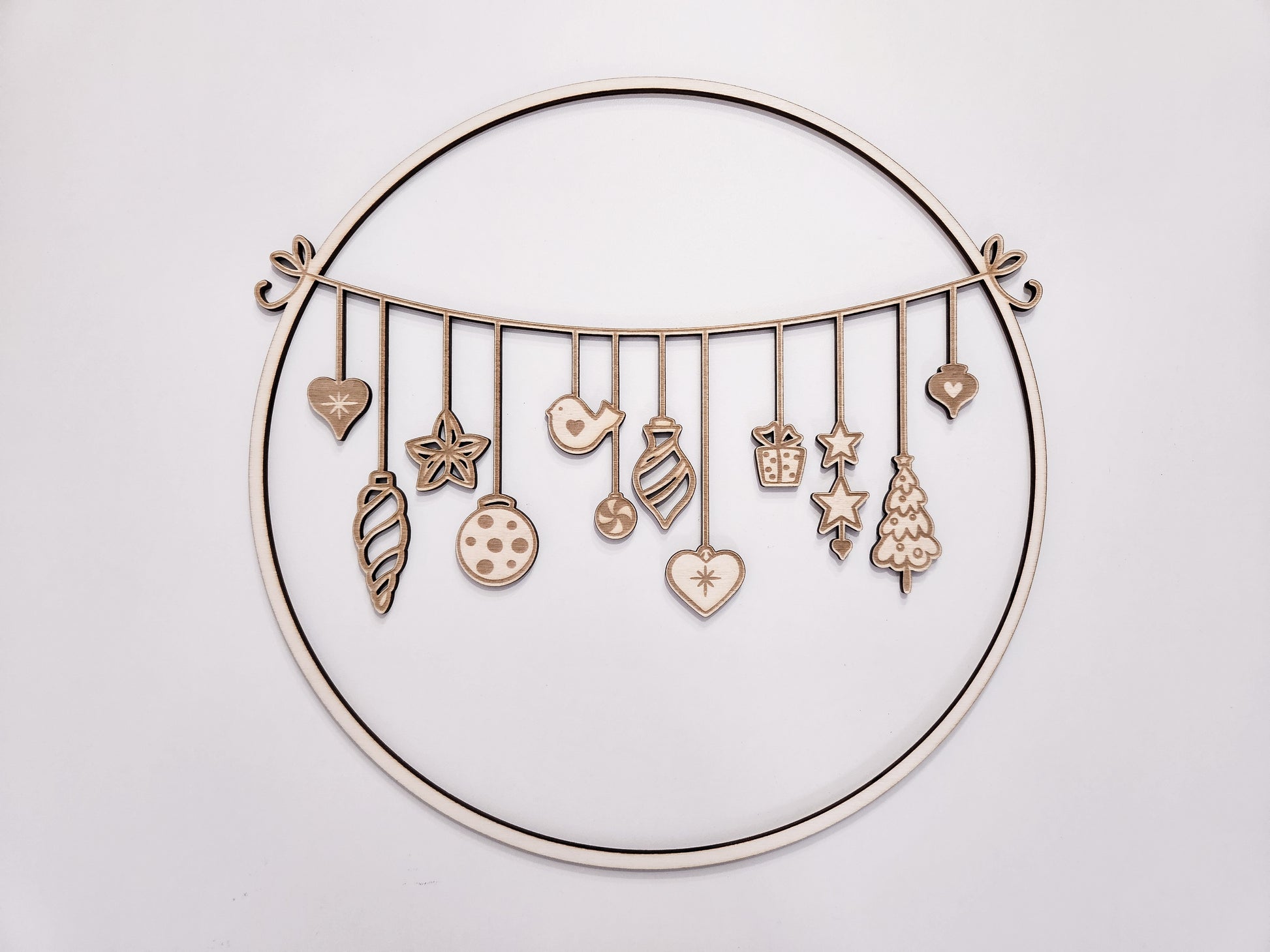 Weihnachtskranz aus Holz mit filigranen Anhängern im skandinavischen Stil als Wand- und Türdeko.