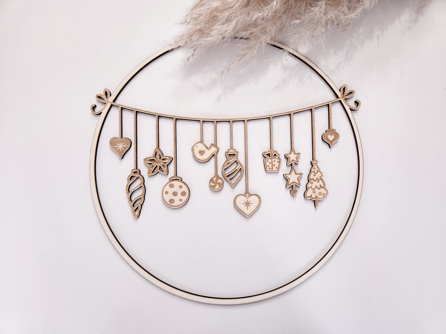 Weihnachtskranz aus Holz mit filigranen Anhängern im skandinavischen Stil als Wand- und Türdeko.