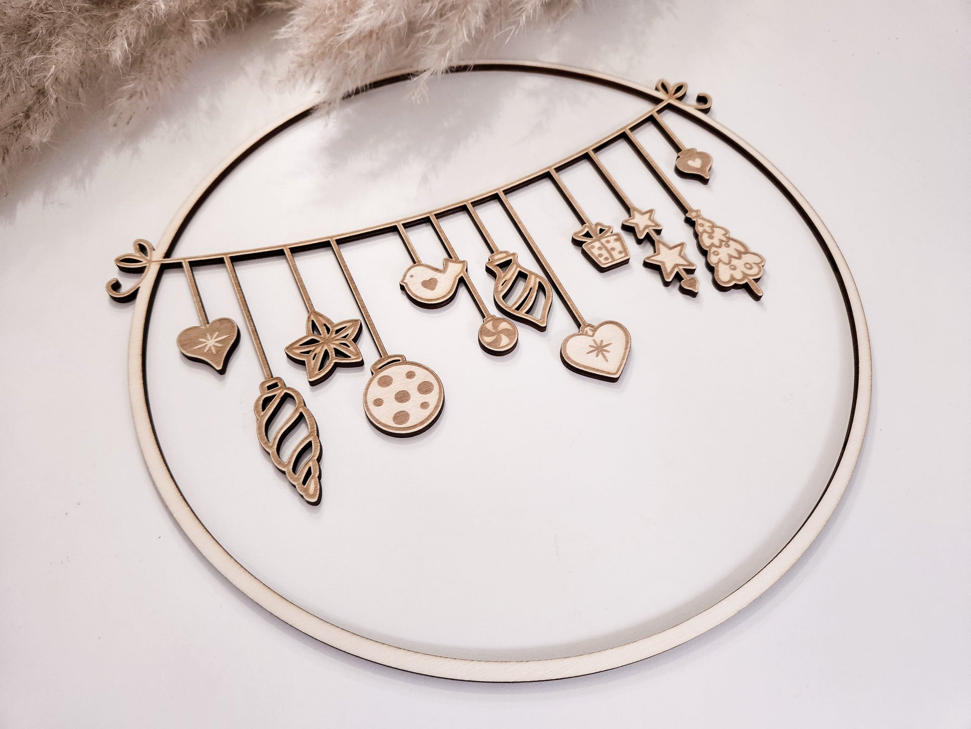 Weihnachtskranz aus Holz mit filigranen Anhängern im skandinavischen Stil als Wand- und Türdeko.