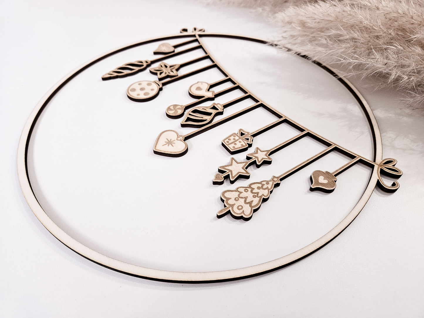 Weihnachtskranz aus Holz mit filigranen Anhängern im skandinavischen Stil als Wand- und Türdeko.