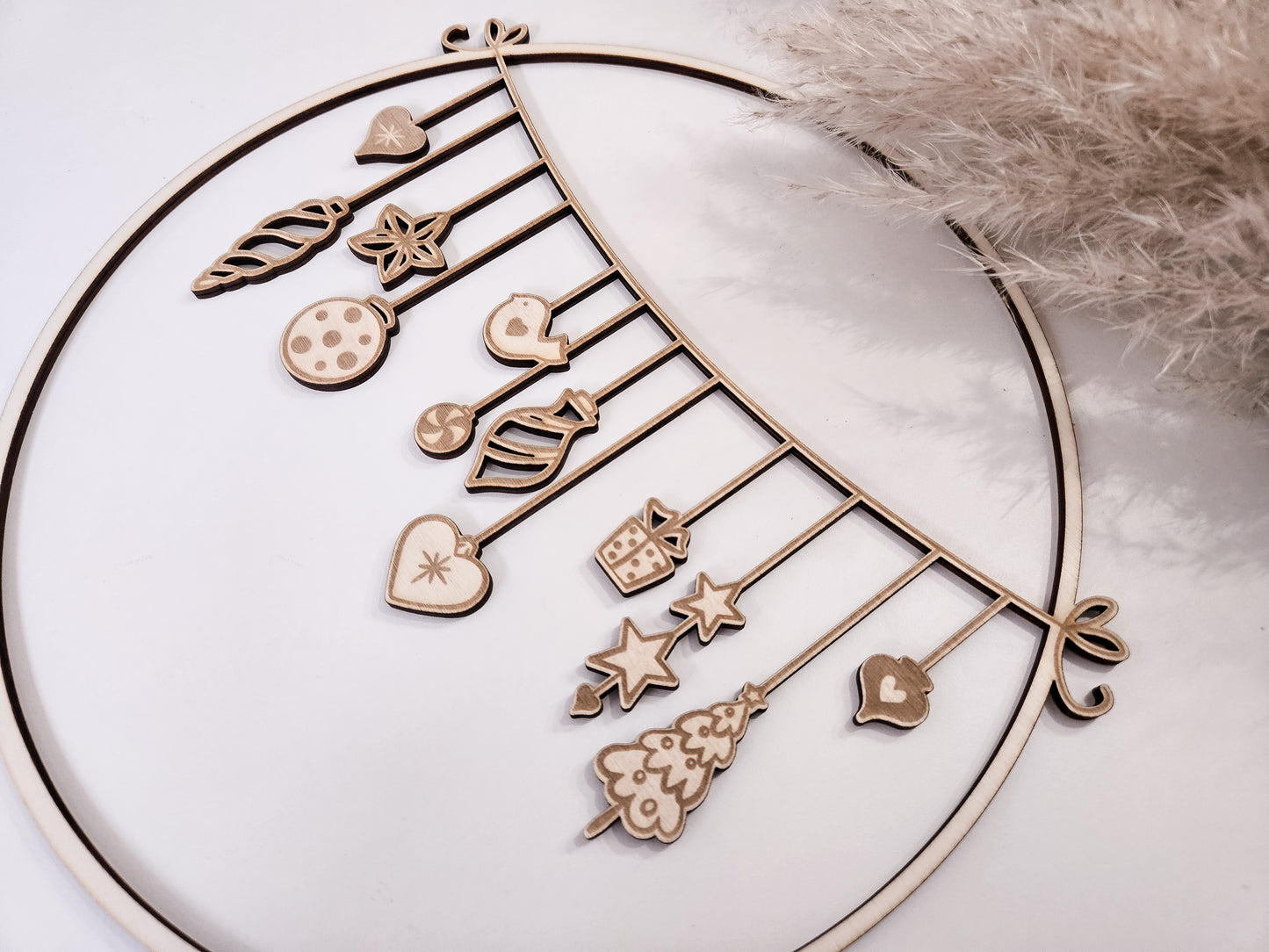 Weihnachtskranz aus Holz mit filigranen Anhängern im skandinavischen Stil als Wand- und Türdeko.