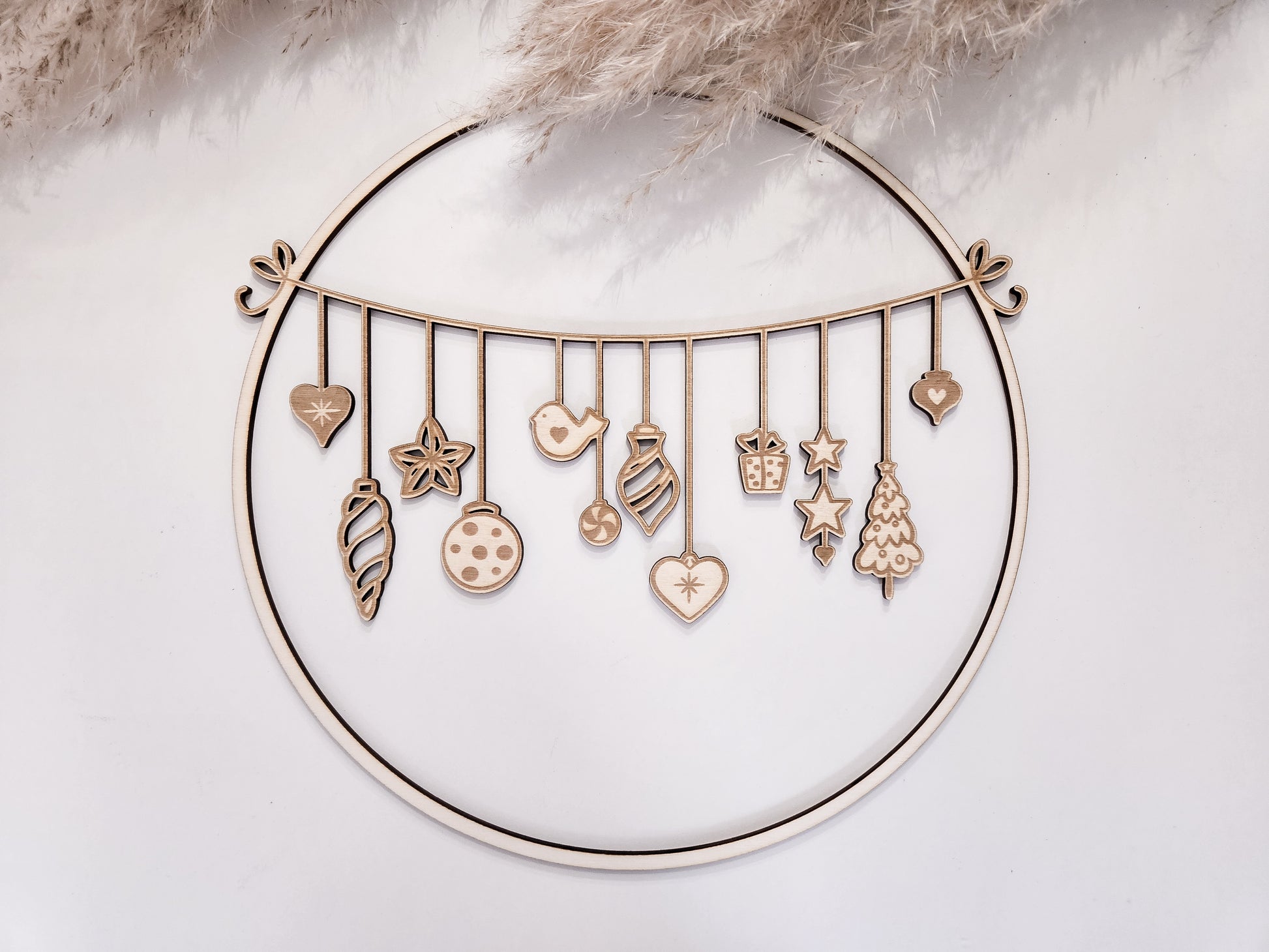 Weihnachtskranz aus Holz mit filigranen Anhängern im skandinavischen Stil als Wand- und Türdeko.