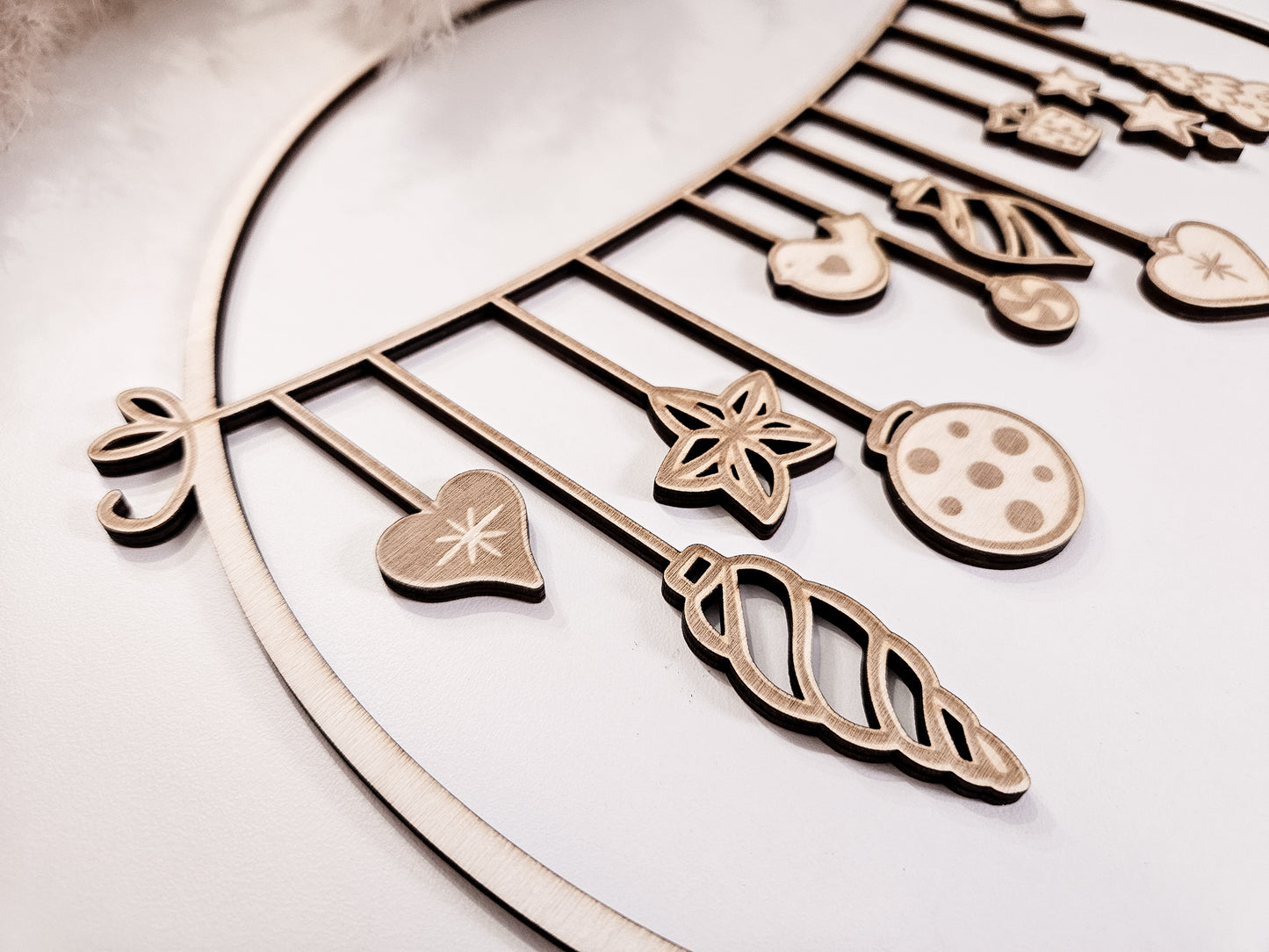 Weihnachtskranz aus Holz mit filigranen Anhängern im skandinavischen Stil als Wand- und Türdeko.