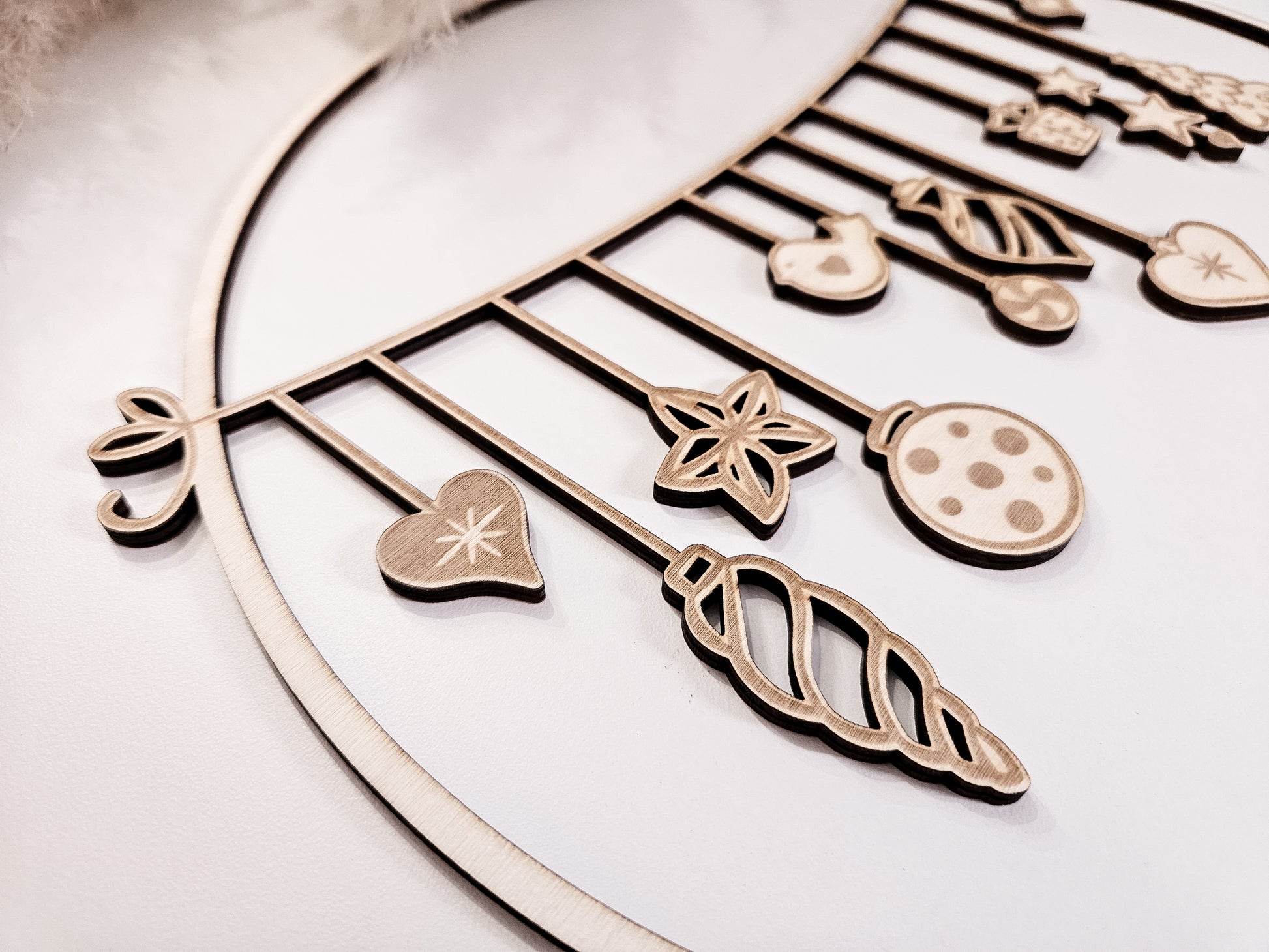 Weihnachtskranz aus Holz mit filigranen Anhängern im skandinavischen Stil als Wand- und Türdeko.