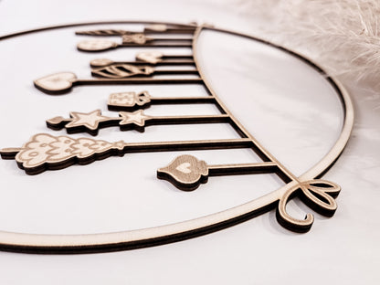 Weihnachtskranz aus Holz mit filigranen Anhängern im skandinavischen Stil als Wand- und Türdeko.