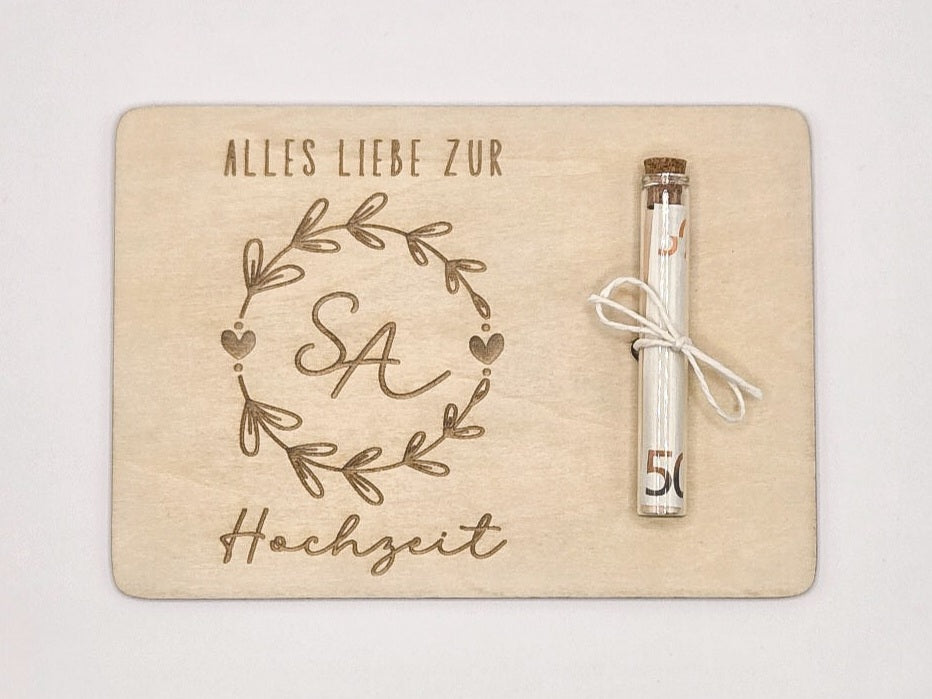 Holzkarte mit Gravur „Alles Liebe zur Hochzeit“, Initialen im Blumenkranz und Glasröhrchen als Geldgeschenk.