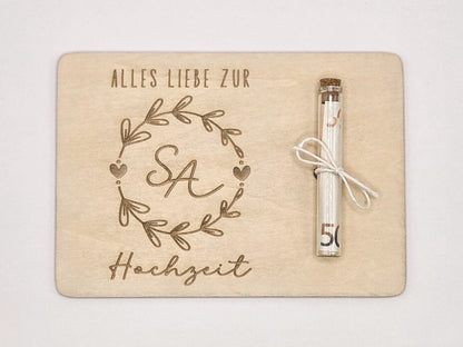 Holzkarte mit Gravur „Alles Liebe zur Hochzeit“, Initialen im Blumenkranz und Glasröhrchen als Geldgeschenk.