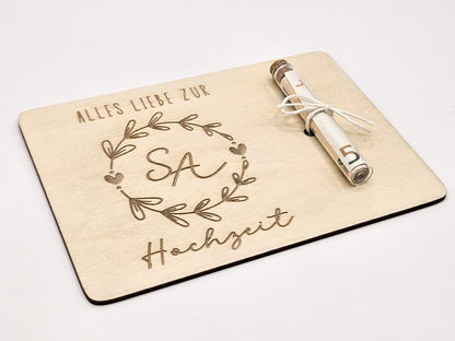 Holzkarte mit Gravur „Alles Liebe zur Hochzeit“, Initialen im Blumenkranz und Glasröhrchen als Geldgeschenk.