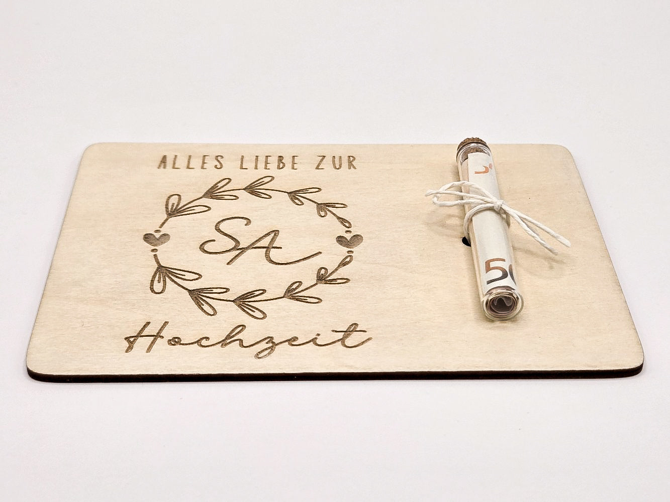 Holzkarte mit Gravur „Alles Liebe zur Hochzeit“, Initialen im Blumenkranz und Glasröhrchen als Geldgeschenk.