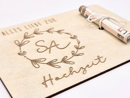 Holzkarte mit Gravur „Alles Liebe zur Hochzeit“, Initialen im Blumenkranz und Glasröhrchen als Geldgeschenk.