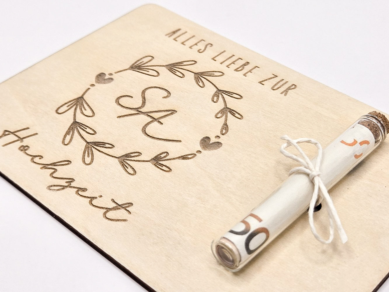 Holzkarte mit Gravur „Alles Liebe zur Hochzeit“, Initialen im Blumenkranz und Glasröhrchen als Geldgeschenk.