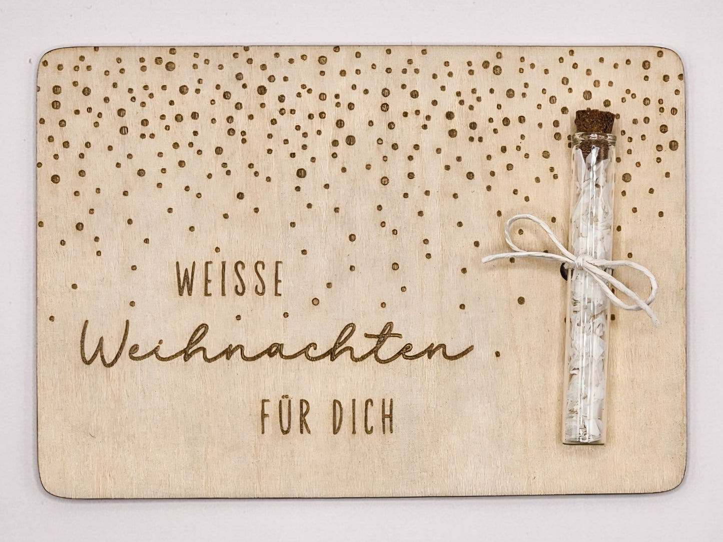 Holzkarte „Weiße Weihnachten“ mit Glasröhrchen, Gravur und winterlicher Deko im skandinavischen Stil auf hellem Holztisch