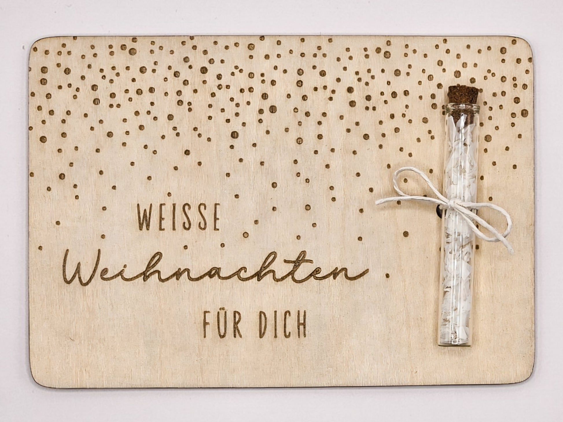 Holzkarte „Weiße Weihnachten“ mit Glasröhrchen, Gravur und winterlicher Deko im skandinavischen Stil auf hellem Holztisch