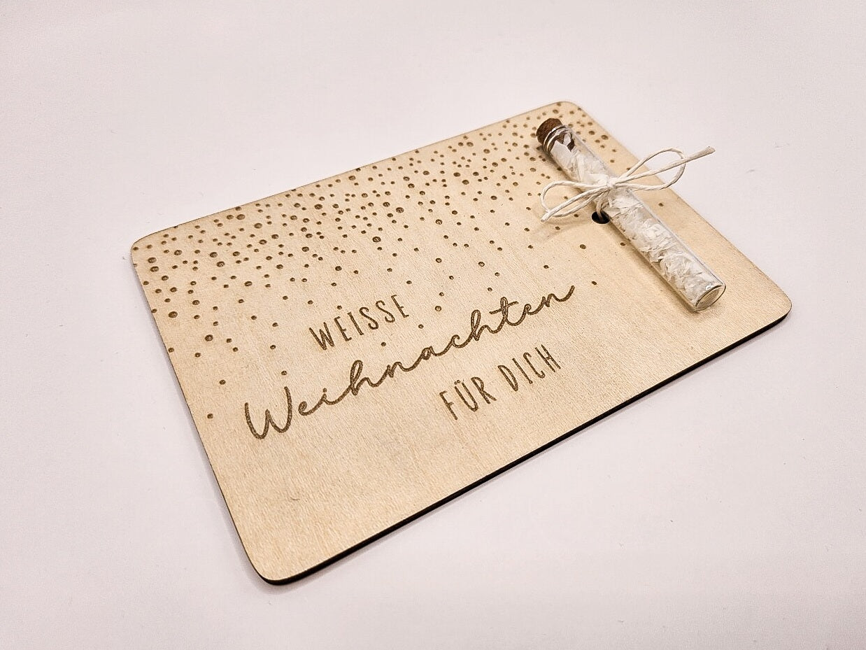 Holzkarte „Weiße Weihnachten“ mit Glasröhrchen, Gravur und winterlicher Deko im skandinavischen Stil auf hellem Holztisch