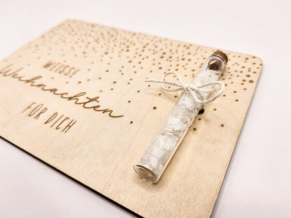 Holzkarte „Weiße Weihnachten“ mit Glasröhrchen, Gravur und winterlicher Deko im skandinavischen Stil auf hellem Holztisch