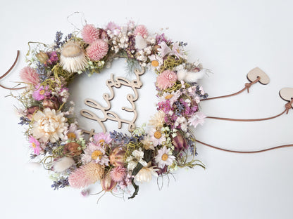Personalisierter Holzring mit Name als Blumenkranz Einsatz im Skandi Stil, filigraner Schriftzug aus Holz für Trockenblumen Kranz Deko, Türkranz personalisiert mit Herz Anhängern, natürlicher Holz Schriftzug für DIY Kranz, modernes Türschild mit Namen, Geschenkidee Einzug Hochzeit Familie, Kranz Schild personalisiert, Boho Wanddeko mit Holzring und Namensgravur, minimalistisches Design, handgemachte Dekoration für Zuhause, individuelle Kranzgestaltung mit Holz Schriftzug und Anhängern