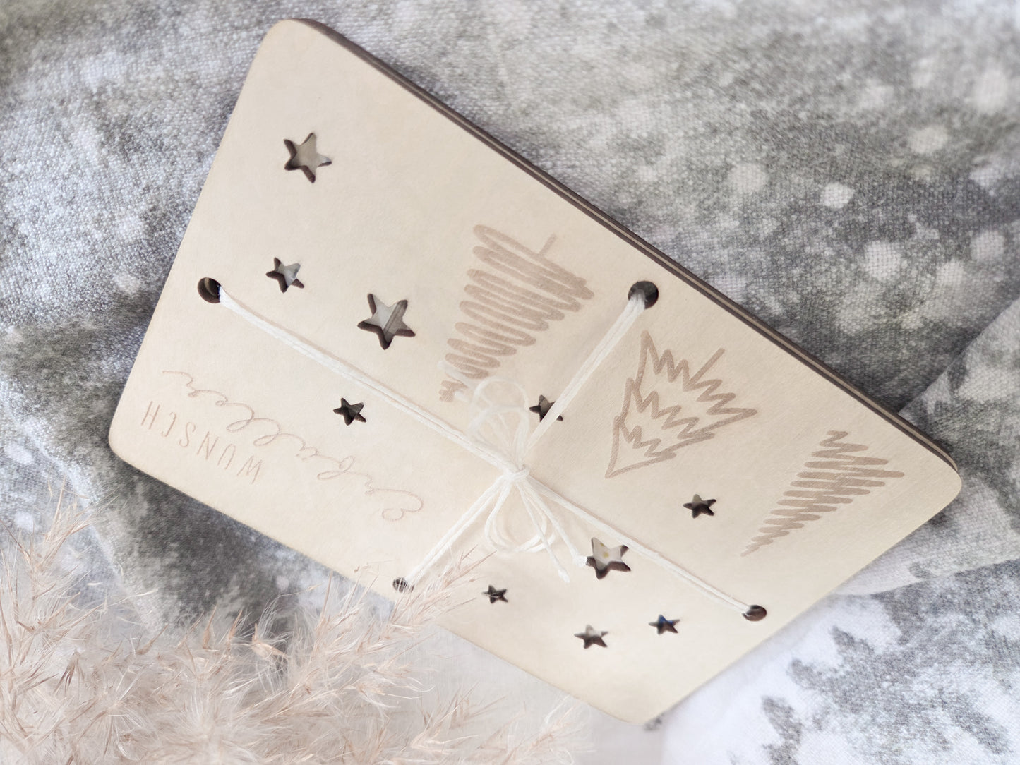 „Wunsch-Erfüller Holzkarte aus hellem Holz mit Tannenbaum-Gravur und Stern-Ausstanzungen – Weihnachts-Geldgeschenk im Scandi-Stil.“