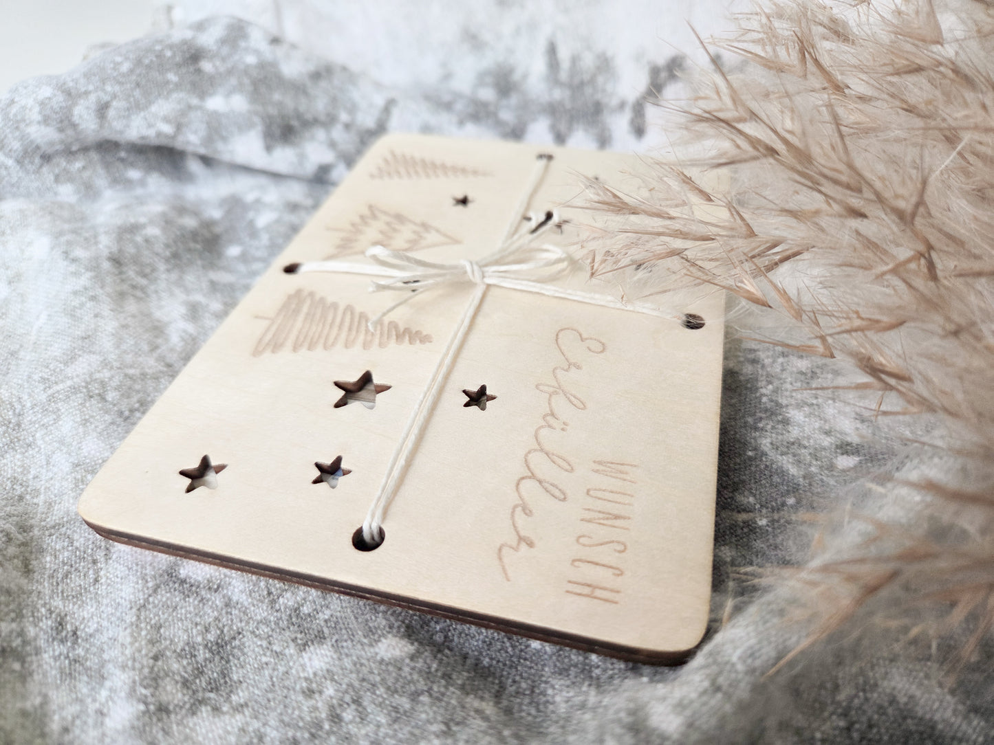 „Wunsch-Erfüller Holzkarte aus hellem Holz mit Tannenbaum-Gravur und Stern-Ausstanzungen – Weihnachts-Geldgeschenk im Scandi-Stil.“