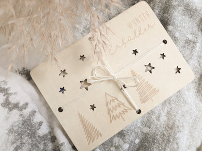 „Wunsch-Erfüller Holzkarte aus hellem Holz mit Tannenbaum-Gravur und Stern-Ausstanzungen – Weihnachts-Geldgeschenk im Scandi-Stil.“