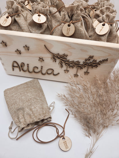 Personalisierte Adventskiste aus hellem Holz mit 3D-Zweig und Sternen, dekoriert mit dem Namen “Alicia”, dazu 24 naturfarbene Jutesäckchen mit gravierten Zahlenanhängern im modernen Scandi-Look.