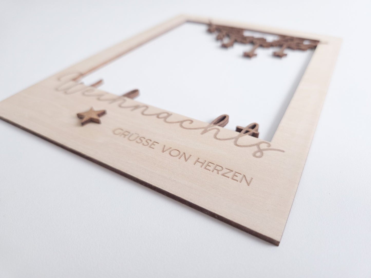 „Holz-Passepartout mit filigran gelasertem Zweig und hängenden Sternen – Weihnachtsrahmen im modernen skandinavischen Stil“