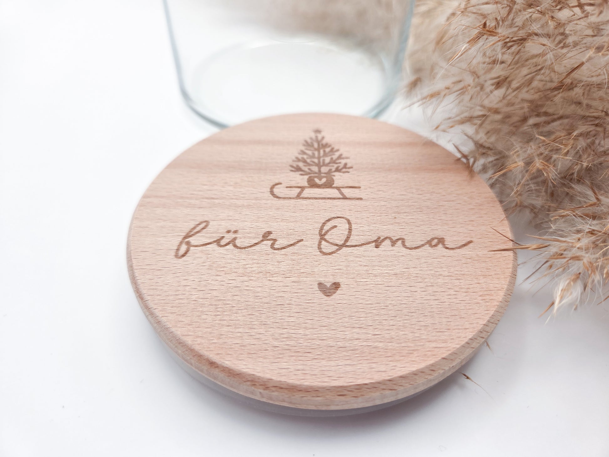 „Personalisierbares Geschenkglas mit hellem Holzdeckel, graviert mit Weihnachtsbaum auf Schlitten und Schriftzug ‚für Oma‘. Skandi, natürlich, handgemacht – Geschenkidee zu Weihnachten.“