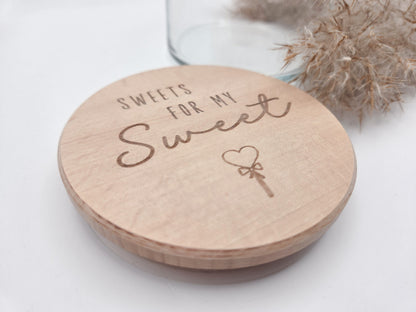 Dekoratives Geschenkglas aus transparentem Glas mit hochwertigem Buchenholzdeckel und liebevoller Lasergravur „Sweets for my Sweet“. Das Glas wird leer geliefert und eignet sich ideal zum individuellen Befüllen mit Süßigkeiten, Pralinen oder kleinen Überraschungen. Zeitloses, minimalistisches Design im Scandi Stil, perfekt als Geschenk zum Valentinstag, Geburtstag, Jahrestag oder für einen Herzensmenschen. Nachhaltig, hochwertig und wiederverwendbar.